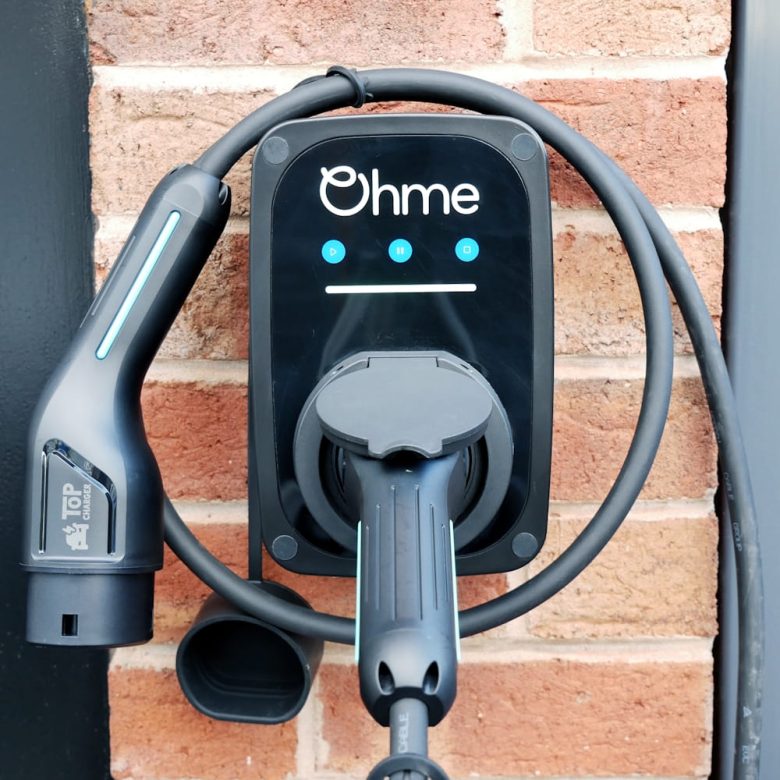 Ohme home charger and cable on a brick wall